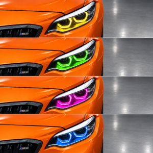 Orangefarbener BMW M2 F87 mit gelbem, grünem, violettem und blauem RGBW-Tagfahrlicht auf grauem Studioboden